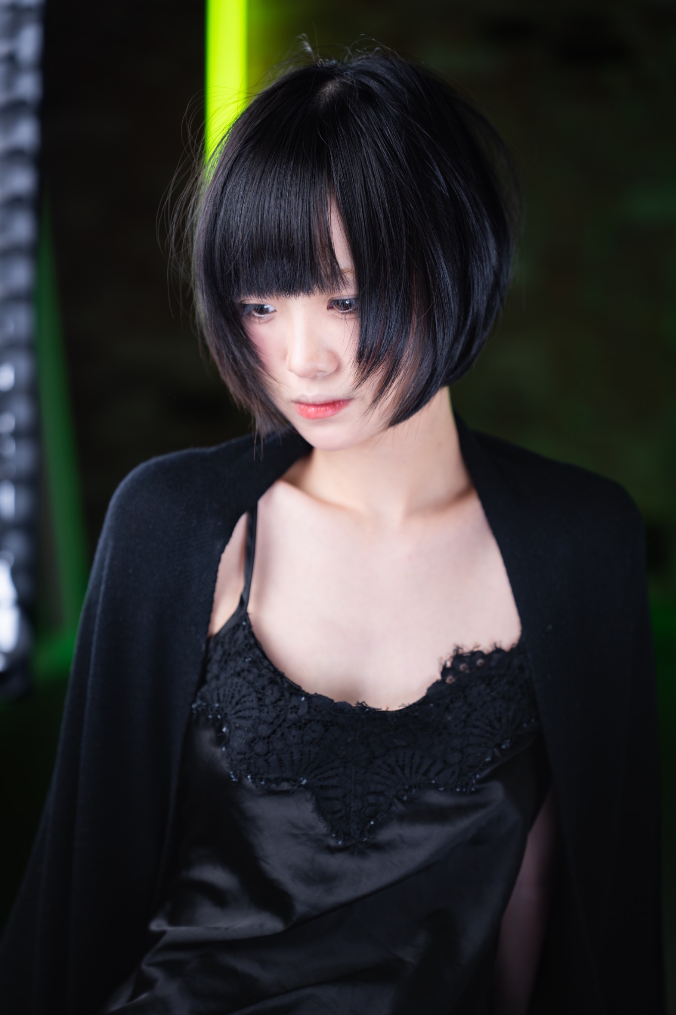 Short black bob haircut with green studio light