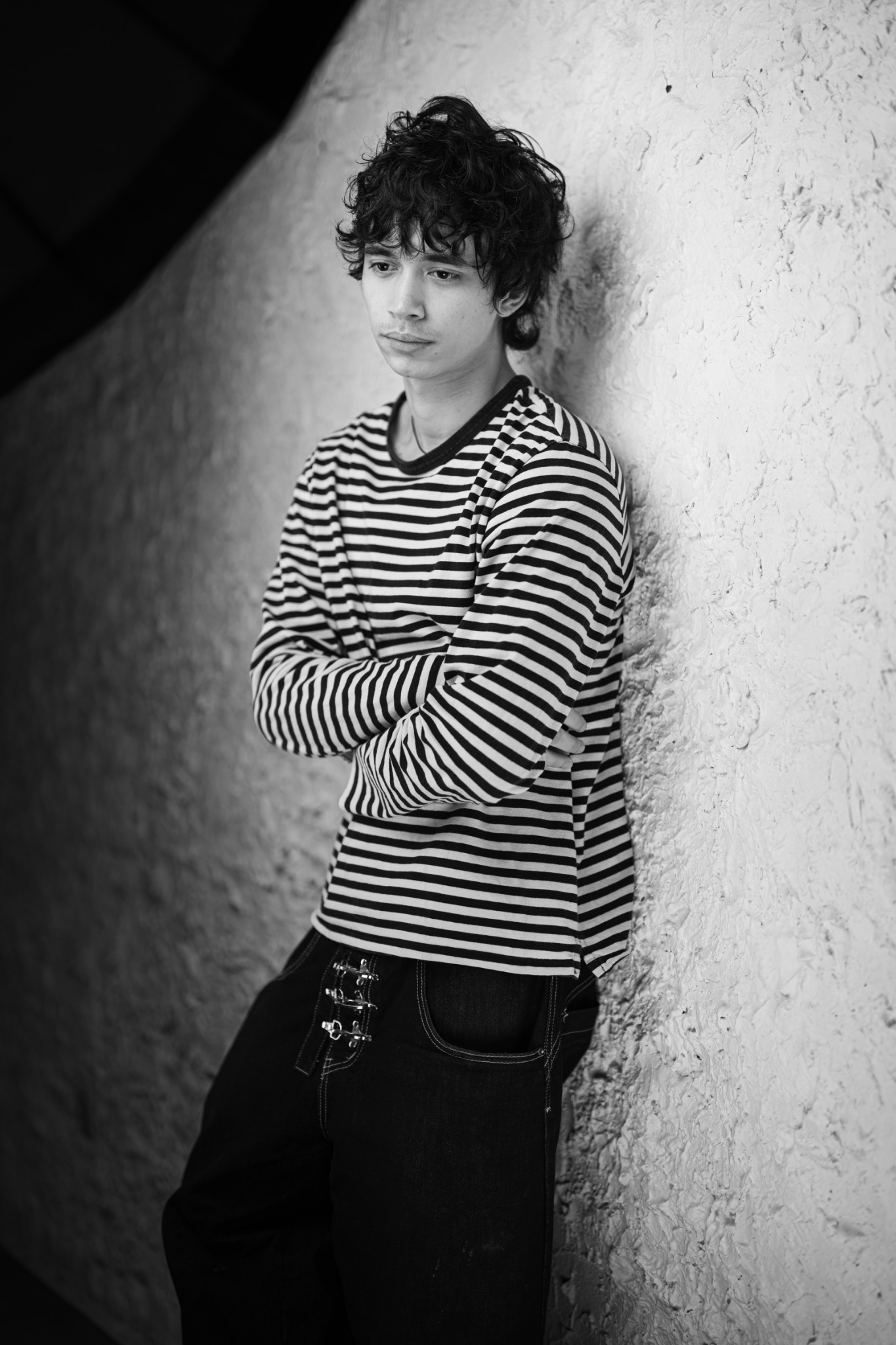 Black-and-white portrait showing a men’s perm style by Daisuke Salon Gents